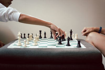 Cropped hand of young man playing chess