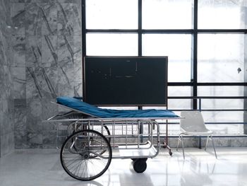 Empty chairs and table against window in building