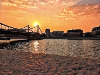 View of bridge over river at sunset