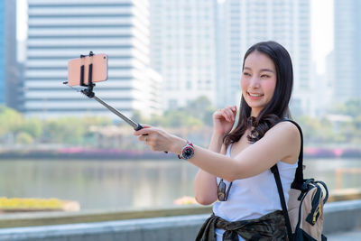 Portrait of woman photographing with mobile phone