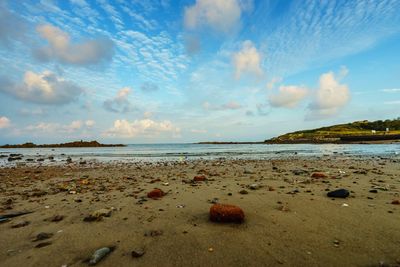 Scenic view of beach against cloudy sky