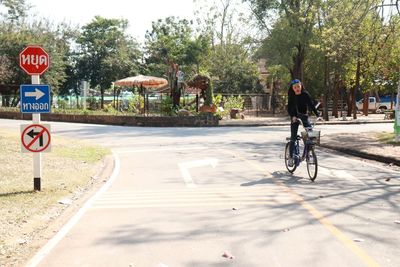 People riding bicycle on road in city