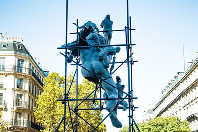 Low angle view of statue against building in city