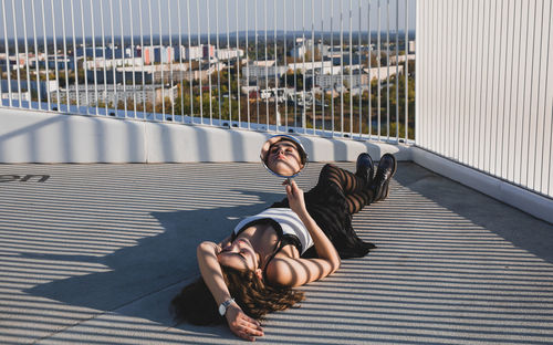 Portrait of young woman on floor in city