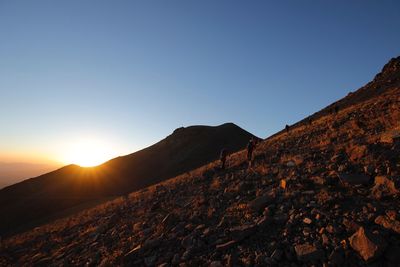 Scenic view of mountains against clear sky during sunset