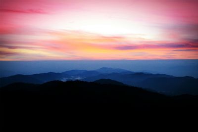 Scenic view of silhouette mountains against sky at sunset