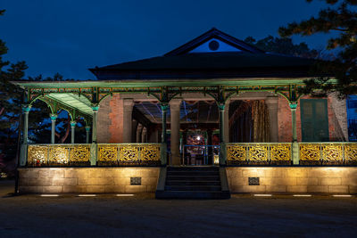 Illuminated temple building against sky at night