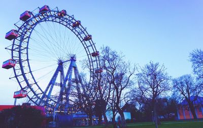 Low angle view of ferris wheel against clear blue sky