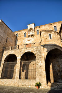 Low angle view of historical building against clear blue sky