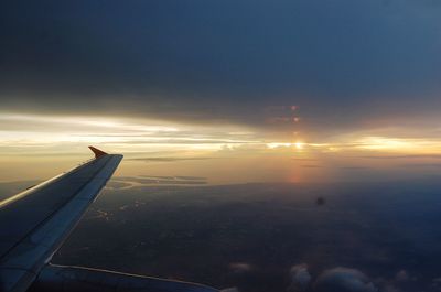 Close-up of airplane wing against sky during sunset