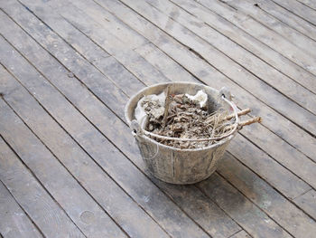 High angle view of garbage in bucket on boardwalk