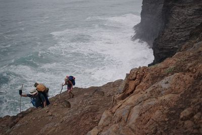 Children standing on rock by sea