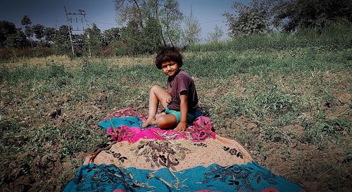 Portrait of young woman sitting on field