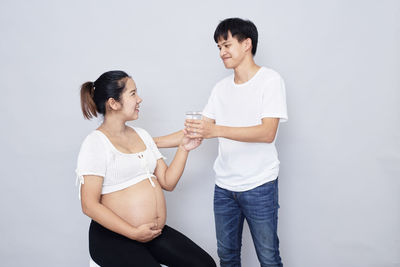 Young couple looking away against white background