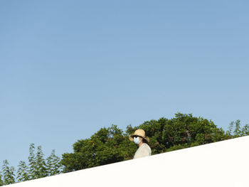Low angle portrait of man standing against clear blue sky