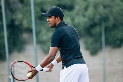 Side view of man playing tennis