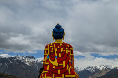 Low angle view of person on snowcapped mountain against sky