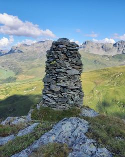 Stack of rocks on mountain against sky