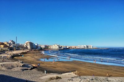 Scenic view of beach against clear blue sky