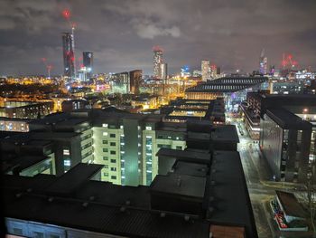 High angle view of illuminated buildings against sky at night
