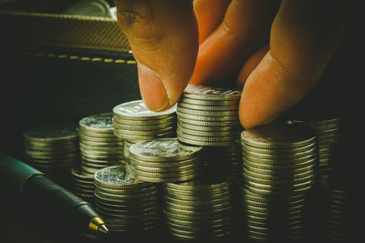 Cropped hand stacking coins on table