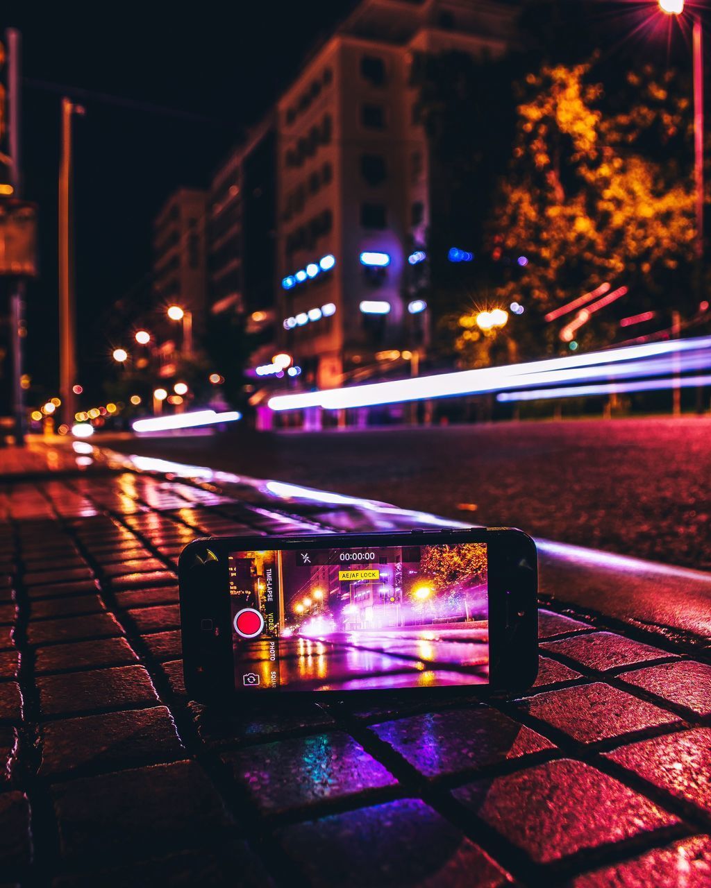 ILLUMINATED BUILDINGS BY STREET AT NIGHT