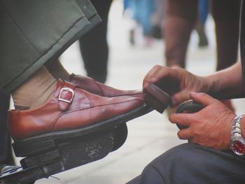 Close-up of man shining shoes outdoors