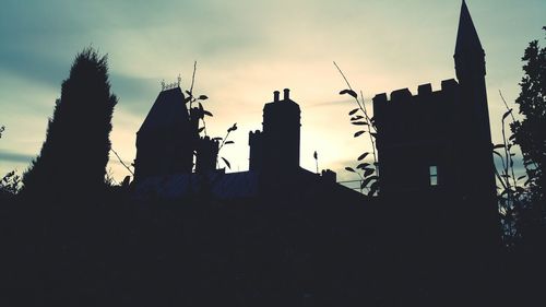 Low angle view of silhouette buildings against sky
