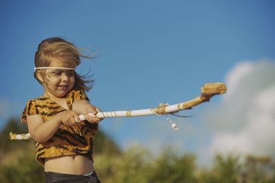 Portrait of young woman standing against clear sky
