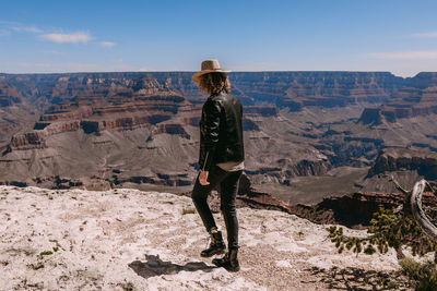 Rear view of man standing on landscape against sky