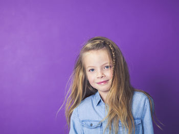 Portrait of smiling girl against purple background