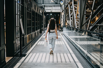 Modern latina young woman walking in large modern mall. young pretty brunette female consumer