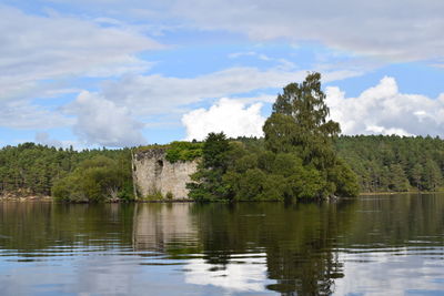 Scenic view of river by trees against sky