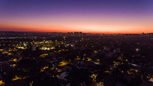 Illuminated cityscape against clear sky at night