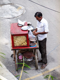 Side view of man preparing food on street