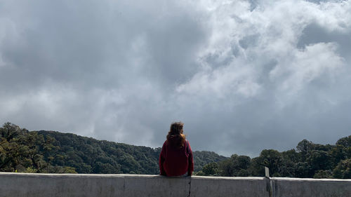 Rear view of woman standing against sky