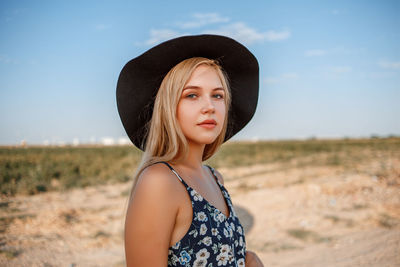 Teenage girl wearing hat against sky