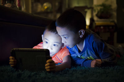 Close-up of siblings using digital tablet at home