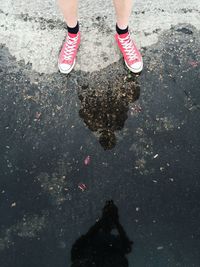 Low section of woman standing in puddle