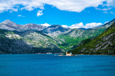 Built structure in calm water against rocky mountains