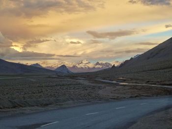 View of country road against cloudy sky