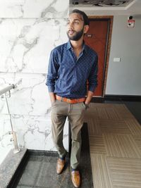 Full length of man looking away while standing in corridor