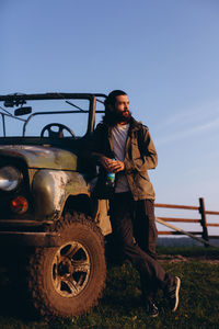 Portrait of man standing on field against sky