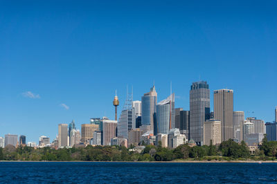 Buildings in city against clear blue sky