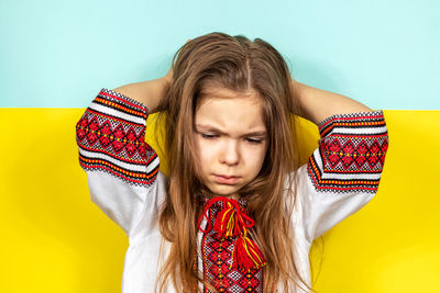 Portrait of young woman against blue background