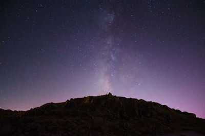 Low angle view of rock formations against sky at night