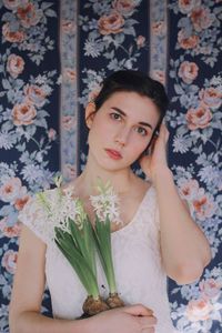 Close-up portrait of young woman holding flowers