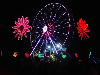 Low angle view of illuminated ferris wheel against sky at night