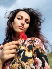 Portrait of young woman holding a poppy