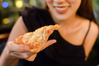 Close-up of woman eating pizza